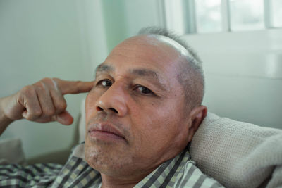 Portrait of man sitting on sofa at home