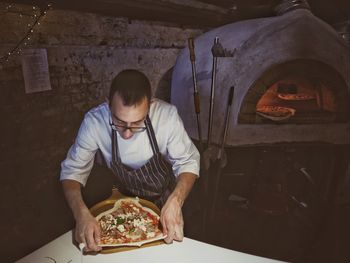 Full length of a man preparing food in restaurant