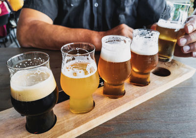 Closeup photo of beer glasses on wooden tasting board.