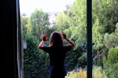Girl standing by window