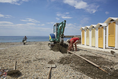 People on beach against sky