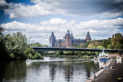 Bridge over river against cloudy sky