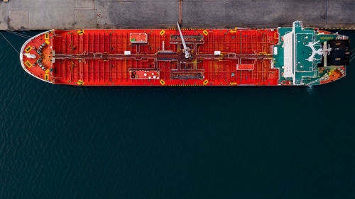 Red shipping oil docked in deep sea aerial top view from drone photography