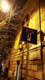 Low angle view of illuminated road sign at night