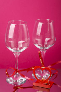 Close-up of wineglass against pink background