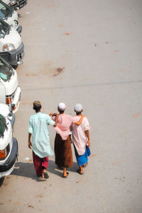 Rear view of people walking on street in city