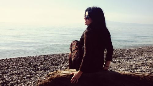 Rear view of man on beach against sky