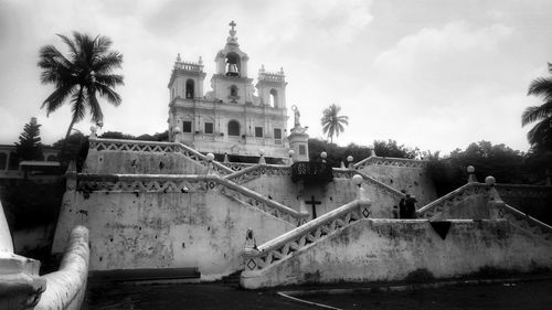 Panoramic view of building and palm trees against sky