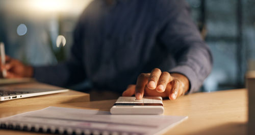 Midsection of man using laptop at table