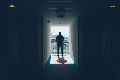 Rear view of man standing at entrance of building