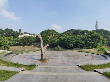 Road amidst trees in park against sky