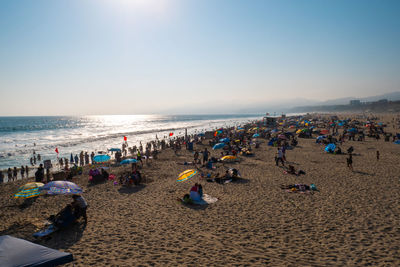 Group of people on beach against sky