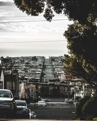 Cars on road against sky in city