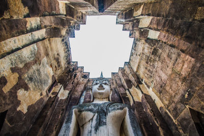 Low angle view of statue in temple against sky