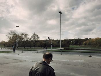 Boy playing soccer on field against sky