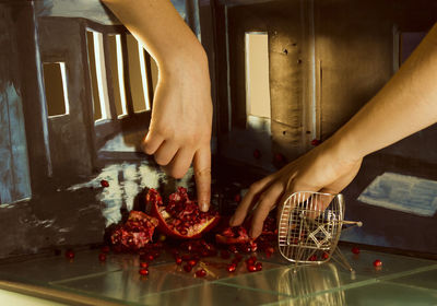 Woman touching crushed pomegranate in a diorama