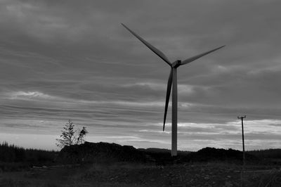 Windmill on field against sky