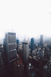 Aerial view of buildings in city against clear sky