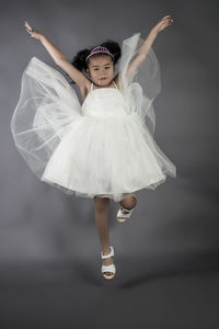 Full length portrait of girl wearing mask against white background