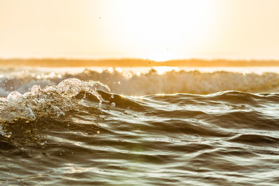Close-up of sea waves against sky during sunset