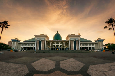 Facade of mosque against sky during sunset