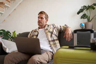 Young woman using laptop while sitting at home