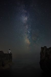 Man looking at scenic view of star field against sky at night