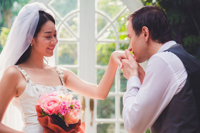 Married couple holding bouquet sitting outdoors