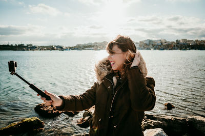 Young woman using mobile phone in water