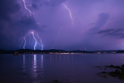 Scenic view of lake at night during storm