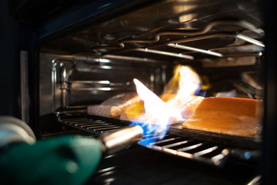 Close-up of burning candles on barbecue grill fish cooking