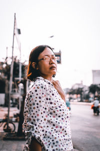 Portrait of woman looking away against sky