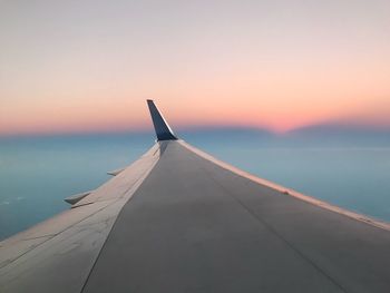 Close-up of airplane flying over sea against sky