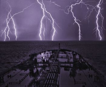 Panoramic view of lightning over sea against dramatic sky