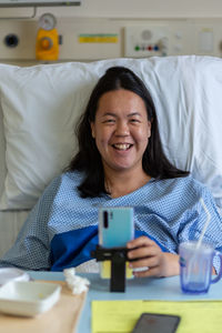 Portrait of smiling woman sitting on bed