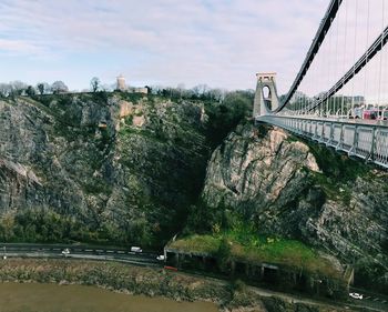 Bridge over river against sky in city