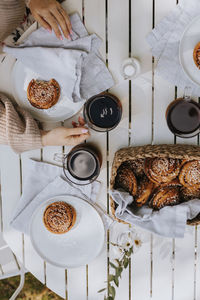 High angle view of coffee mugs and cinnamon buns on wooden table