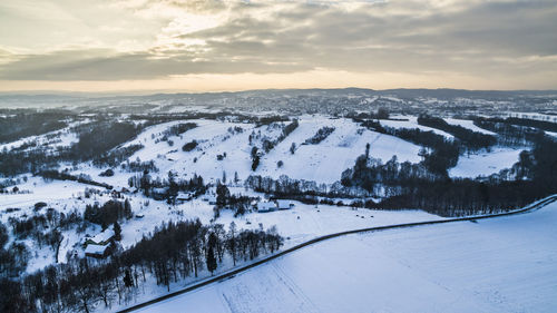 Scenic view of snow covered landscape against sky during sunset