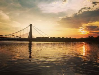 Bridge over river at sunset