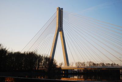 Low angle view of suspension bridge against sky