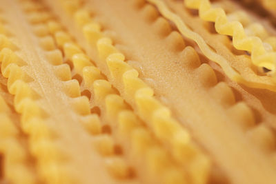 Raw italian pasta called mafaldine , flat and wide pasta with wavy edges  , abstract effect