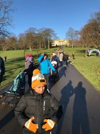 People standing by trees against clear sky