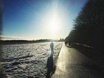 Rear view of woman walking on water against clear sky