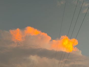 Low angle view of electricity pylon against sky during sunset
