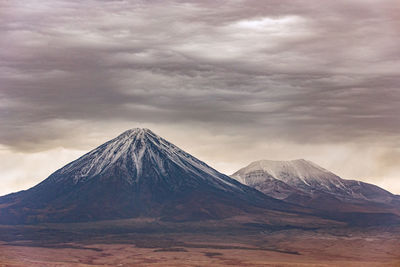 Scenic view of snowcapped mountain against cloudy sky