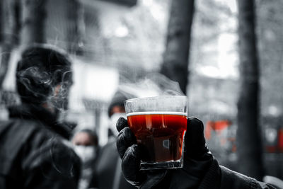 Close-up of person holding beer glass