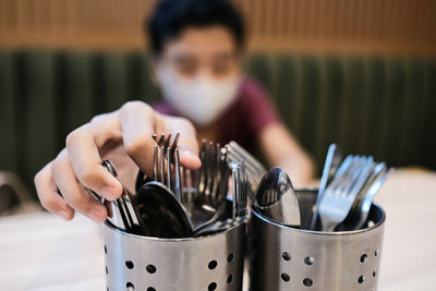 A boy fetching the stainless streel cutleries in a restaurant
