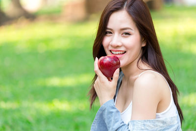 Portrait of smiling woman holding apple