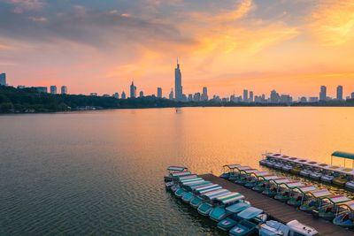 View of buildings at waterfront during sunset