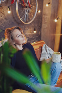 Young woman looking down while sitting on seat